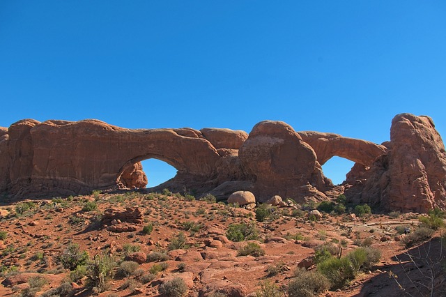 North Window and South Window, two large sandstone arches side by side under a clear blue sky